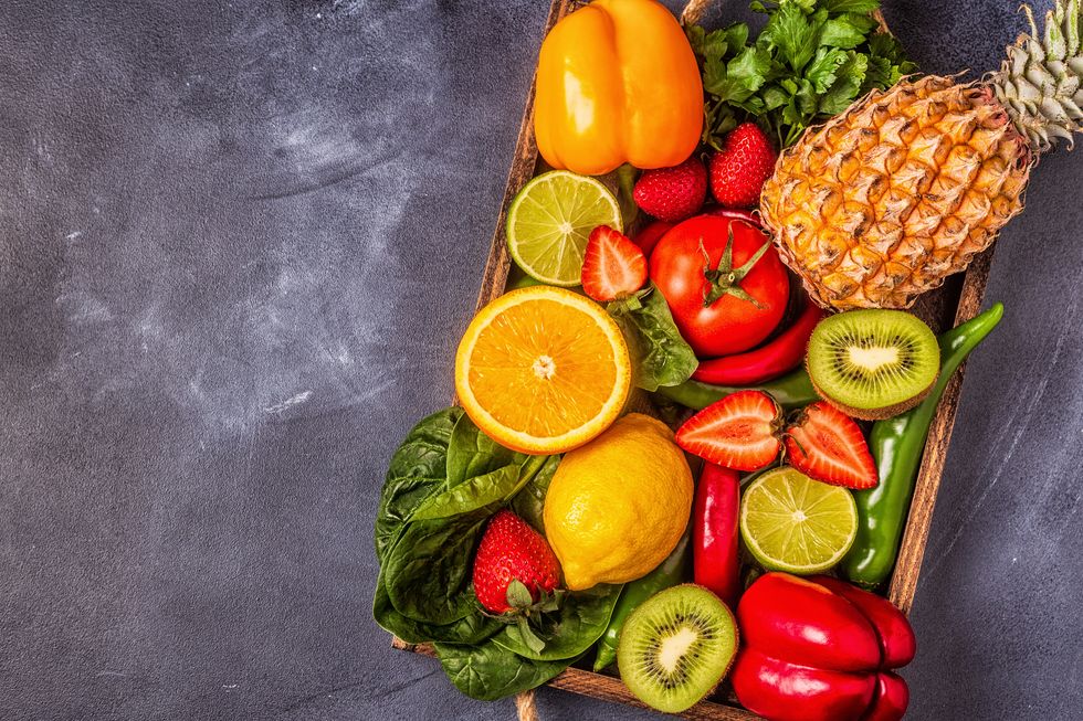 A platter full of fruits and vegetables rich in vitamin C, including citrus fruits, peppers and kale.