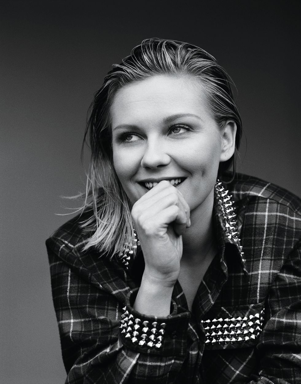Kirsten Dunst wearing a plaid blazer with ornamental metal spikes.