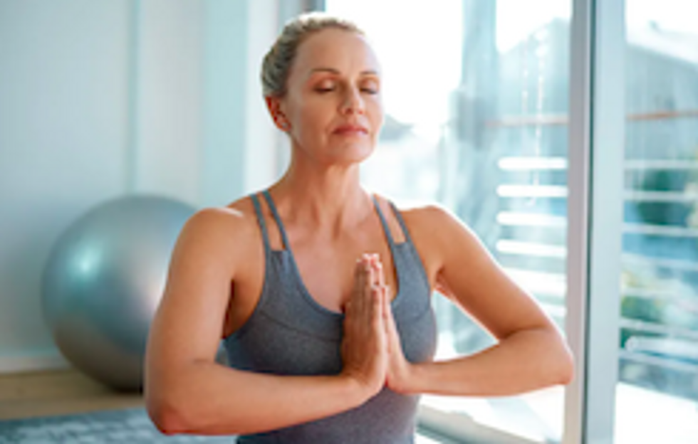 A photo of a woman meditating, which mom can do if you buy her a subscription to the Calm app