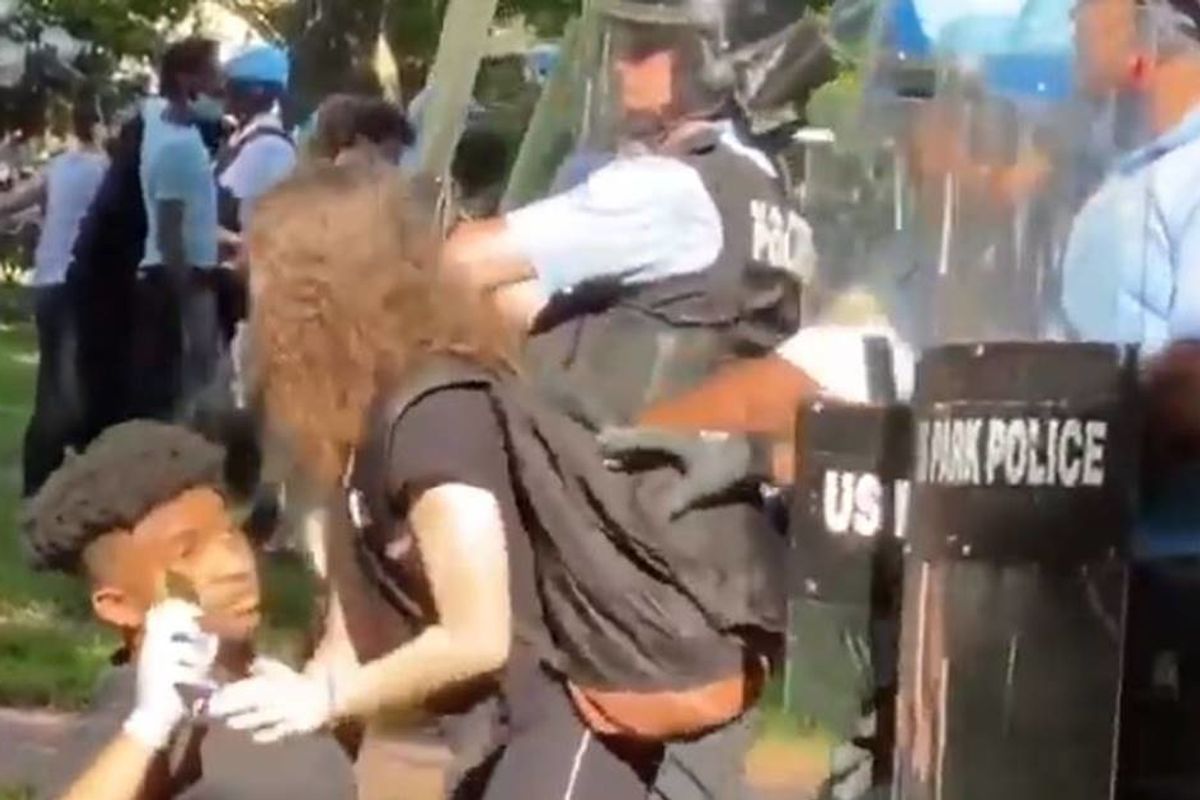 Powerful footage shows a white girl jumping in harm's way to shield a young black man from police