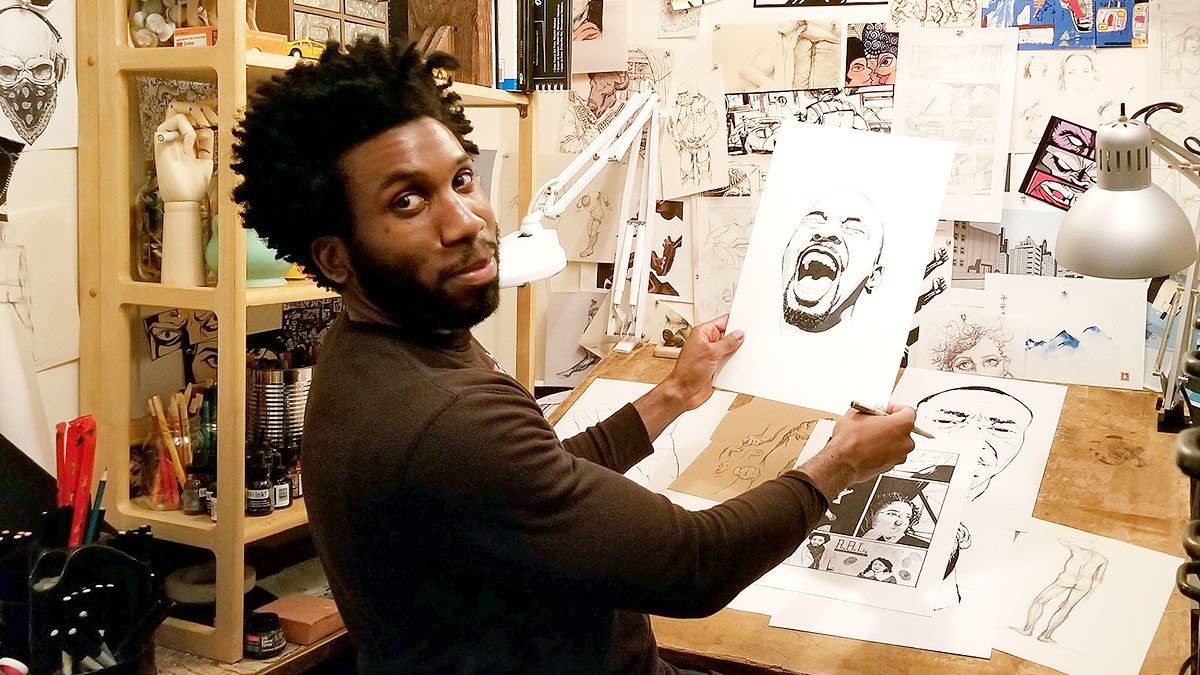 Actor Nyambi Nyambi sitting in front of his drawing table.