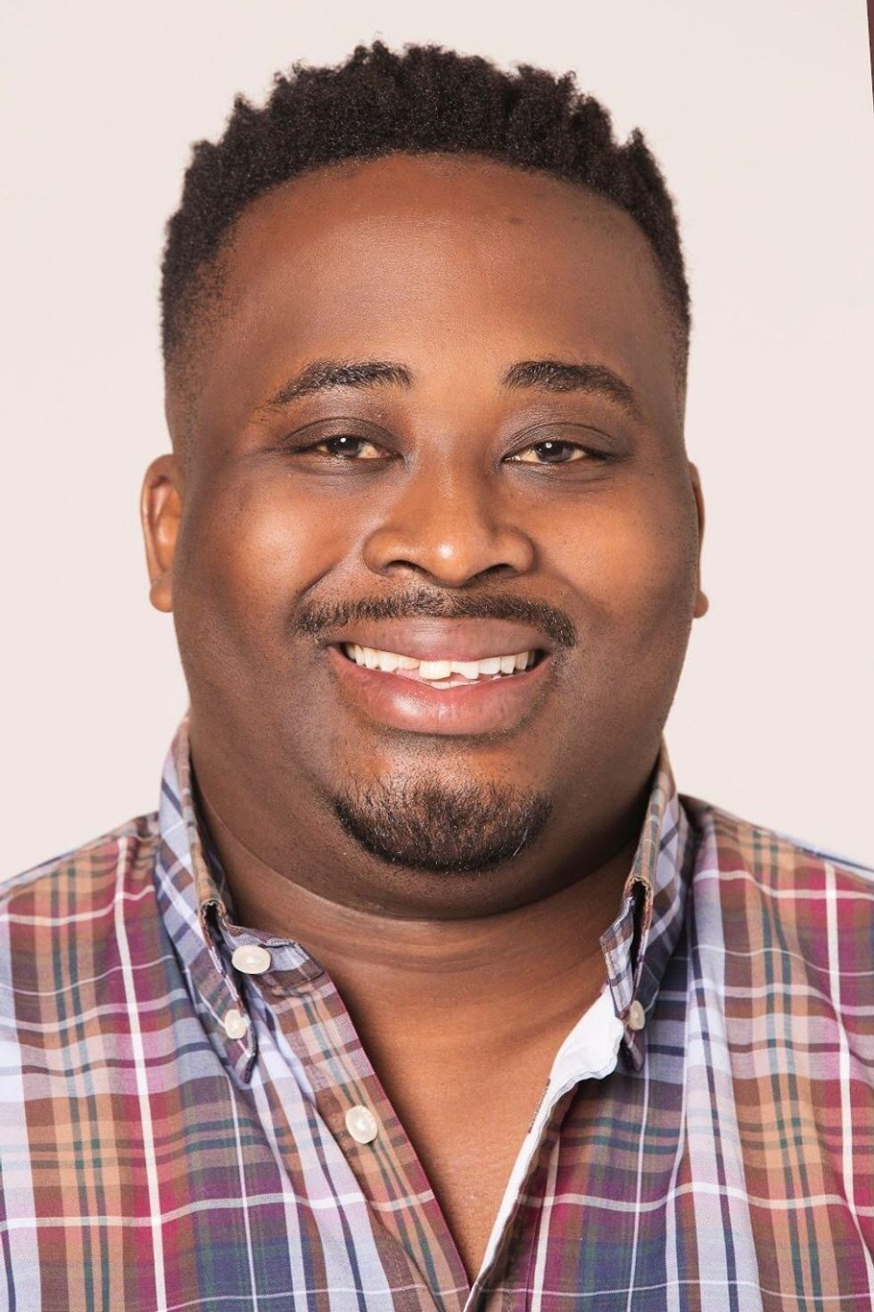A portrait of Mzwandile Sibanda in a checkered shirt. class=
