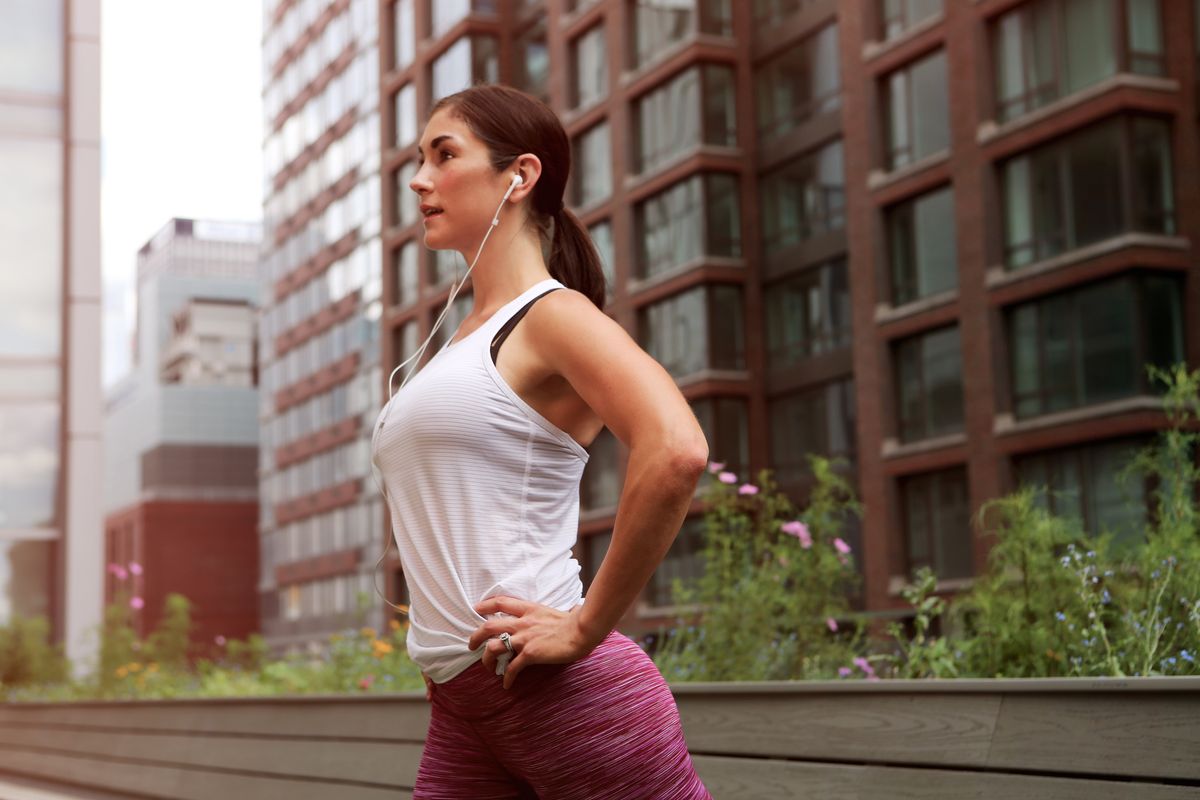 woman exercising outside with earphones in