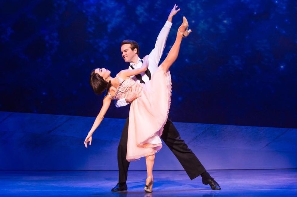 McGee Maddox, dressed in black paints, white blouse and an untied bow tie, lunges to his right while Allison Walsh, wearing a pink dress, leans unti his right arm and kicks her right leg toward the sky.