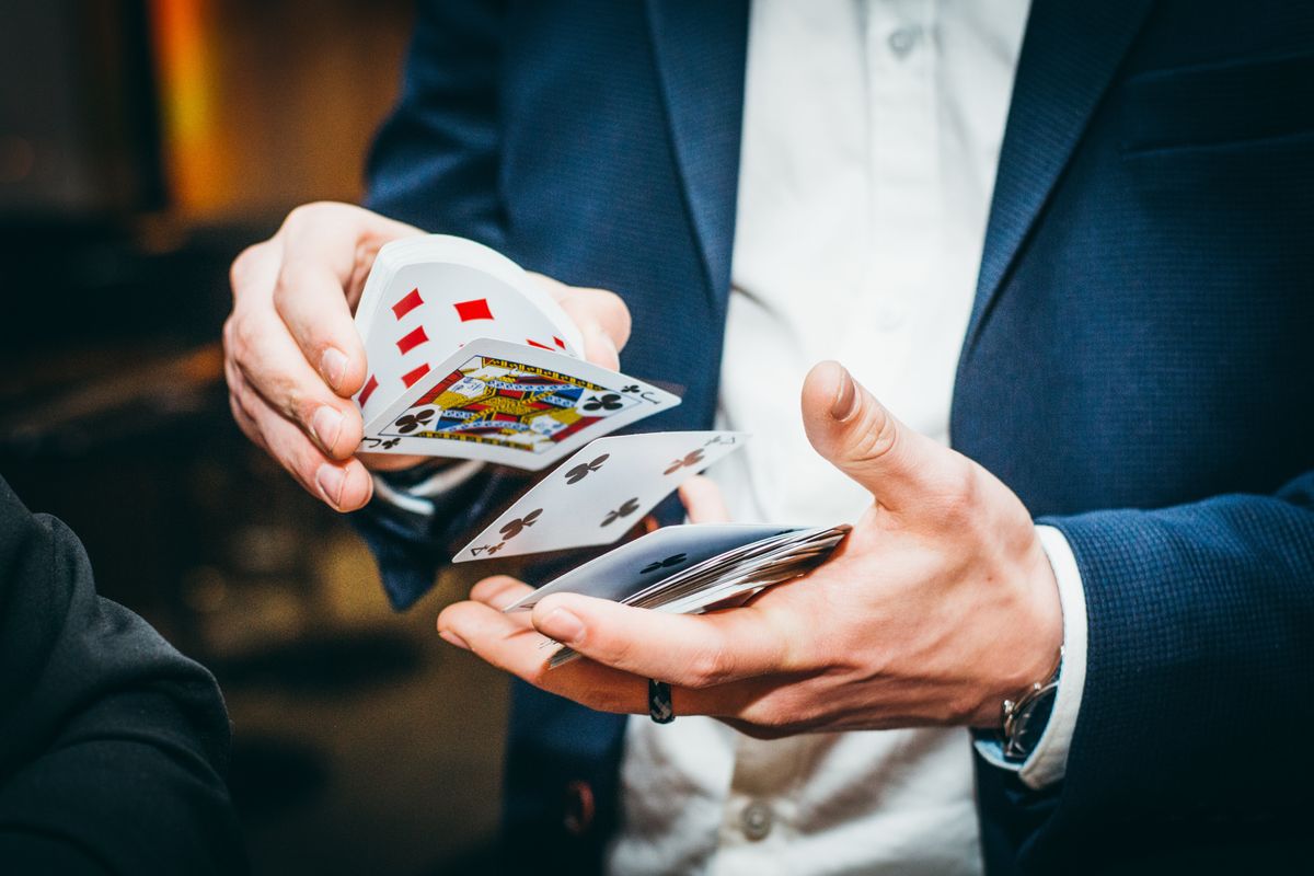 man in suit shuffling cards