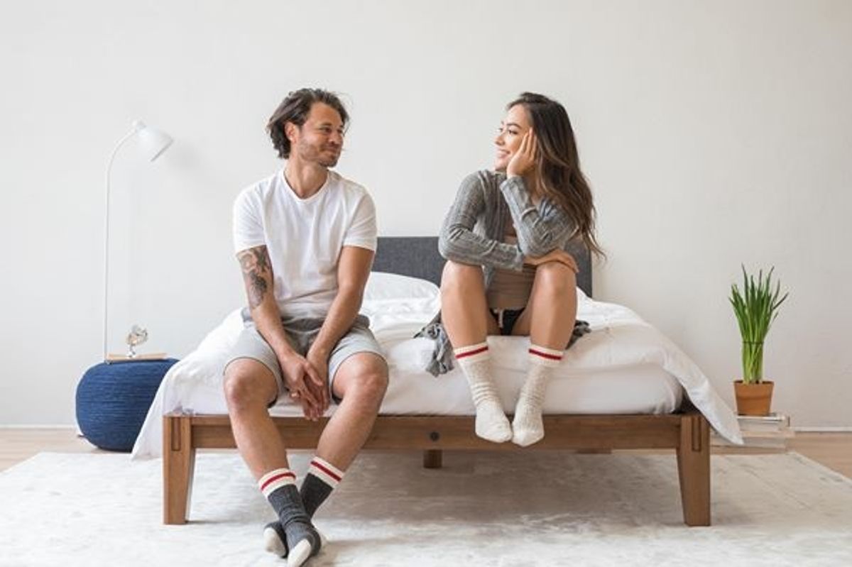 a man and a woman sitting on a thuma bed