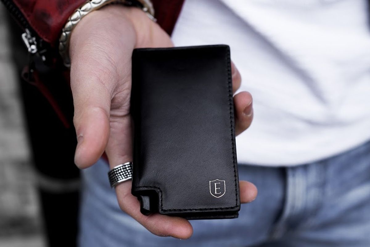 man holding an black ekster wallet
