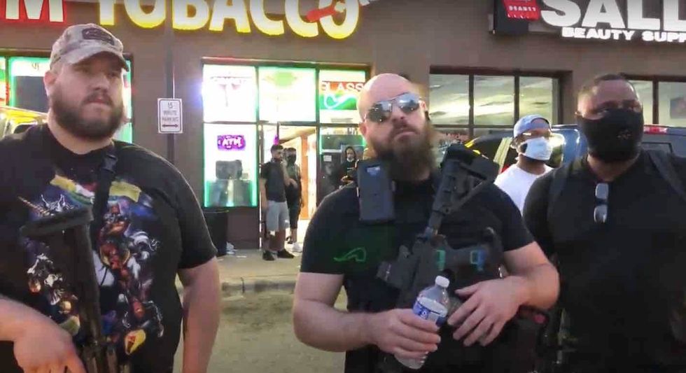 Heavily armed rednecks' who support protesters stand in front of ...