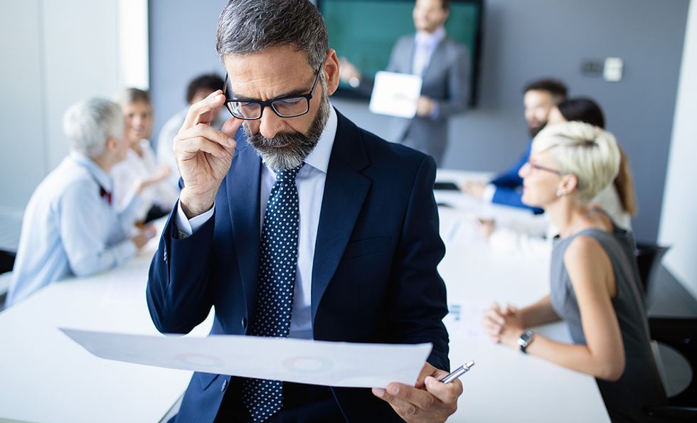 Leader looking over company plans for compliance and governance post-COVID-19