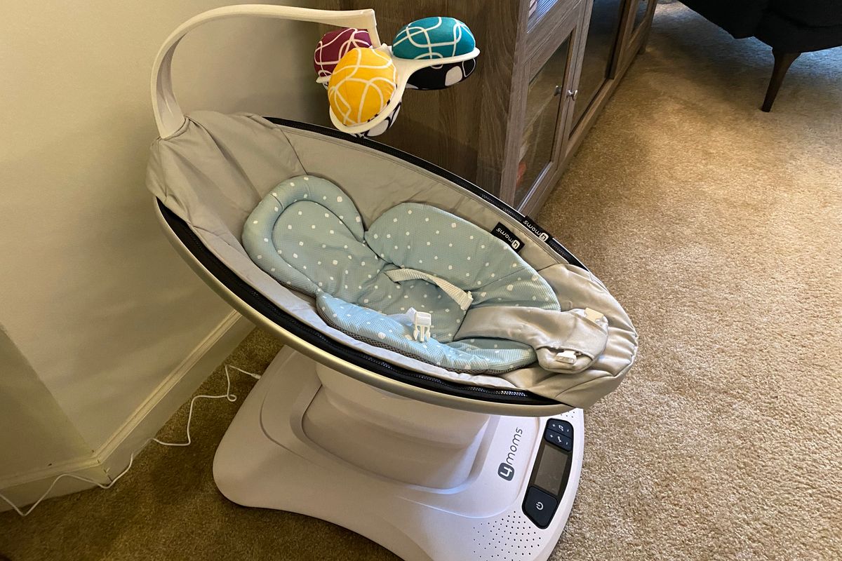 mamaRoo4 with infant insert and mobile plugged into the wall.