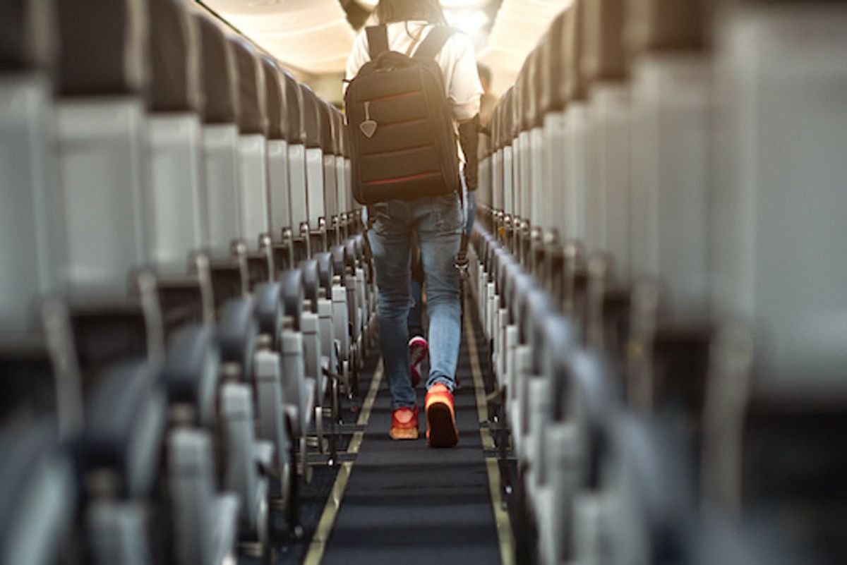 Someone walking down the aisle of an airplane