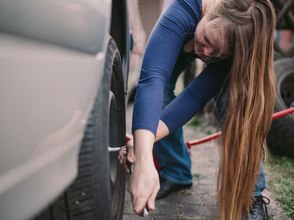 Woman changing a car tire