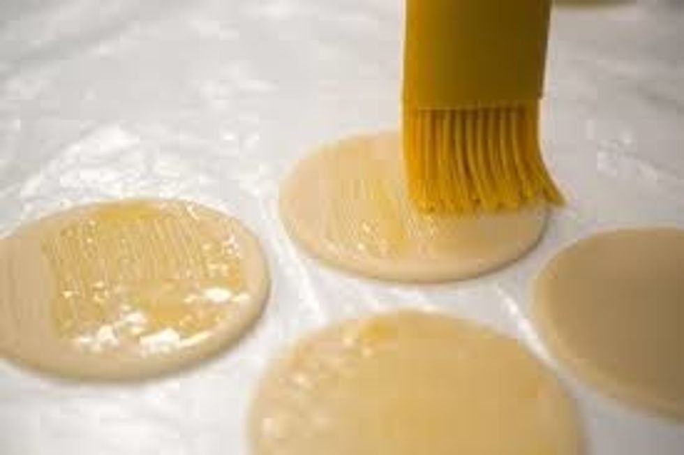 Circles Of Dough Being Glazed