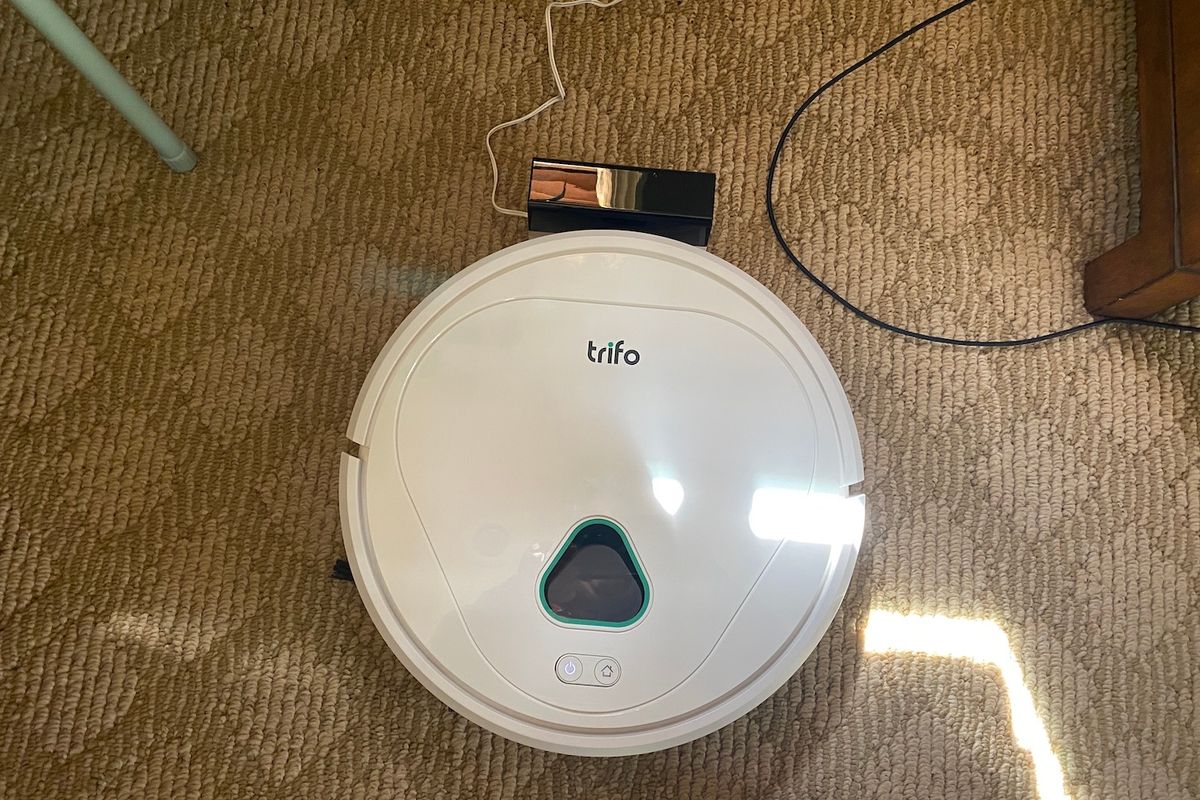 a photo of Trifo Max Home Surveillance Robot Vacuum on the floor charging.