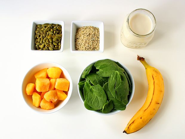 Reúna seus suprimentos: sementes de abóbora, sementes de cânhamo, amêndoa ou leite de soja (escolha soja para obter 6g de proteína a mais), banana (use congelada para obter uma textura mais espessa), espinafre bebê e pedaços de manga congelados.