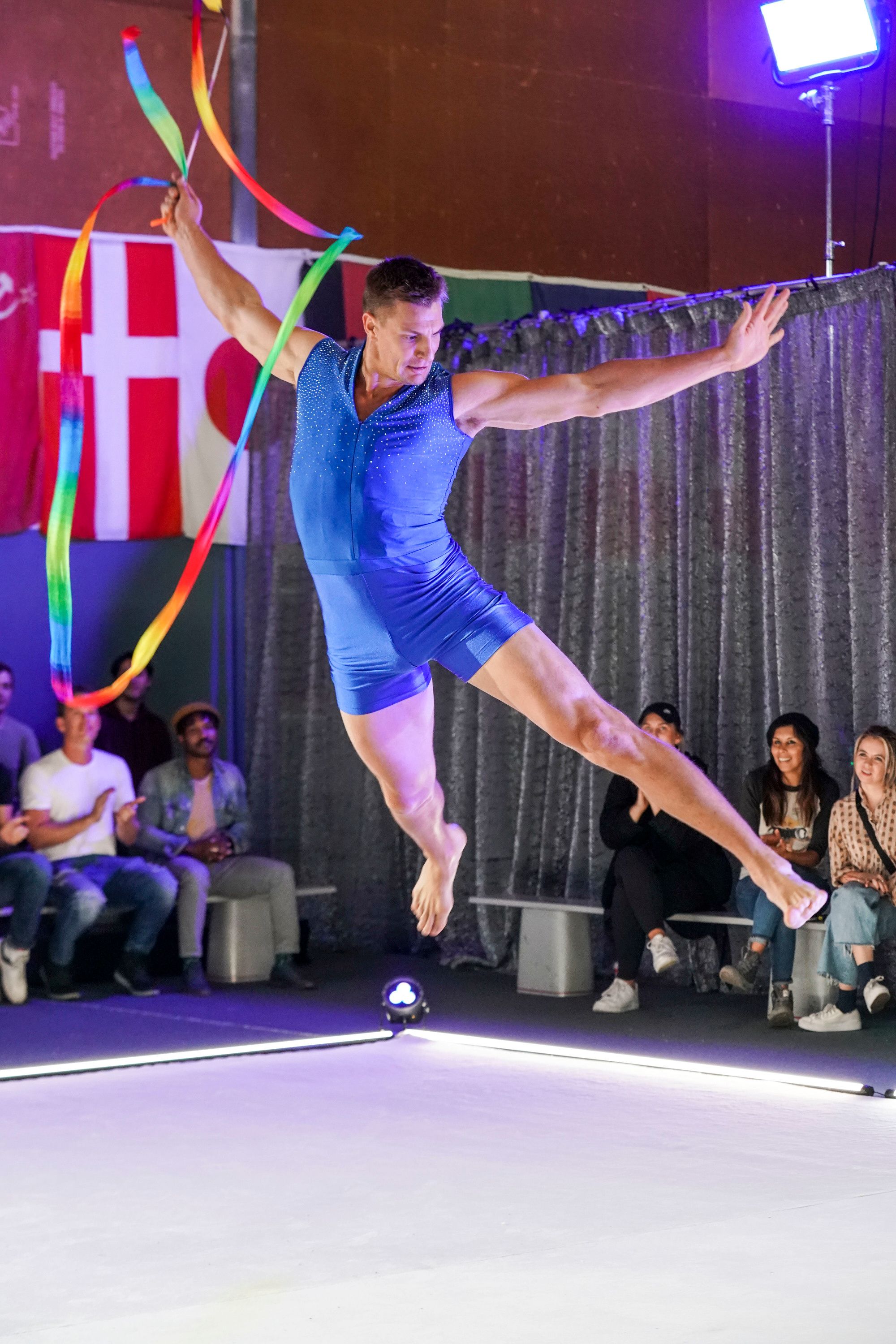 Rob Gronkowski leaps from the floor holding a ribbon