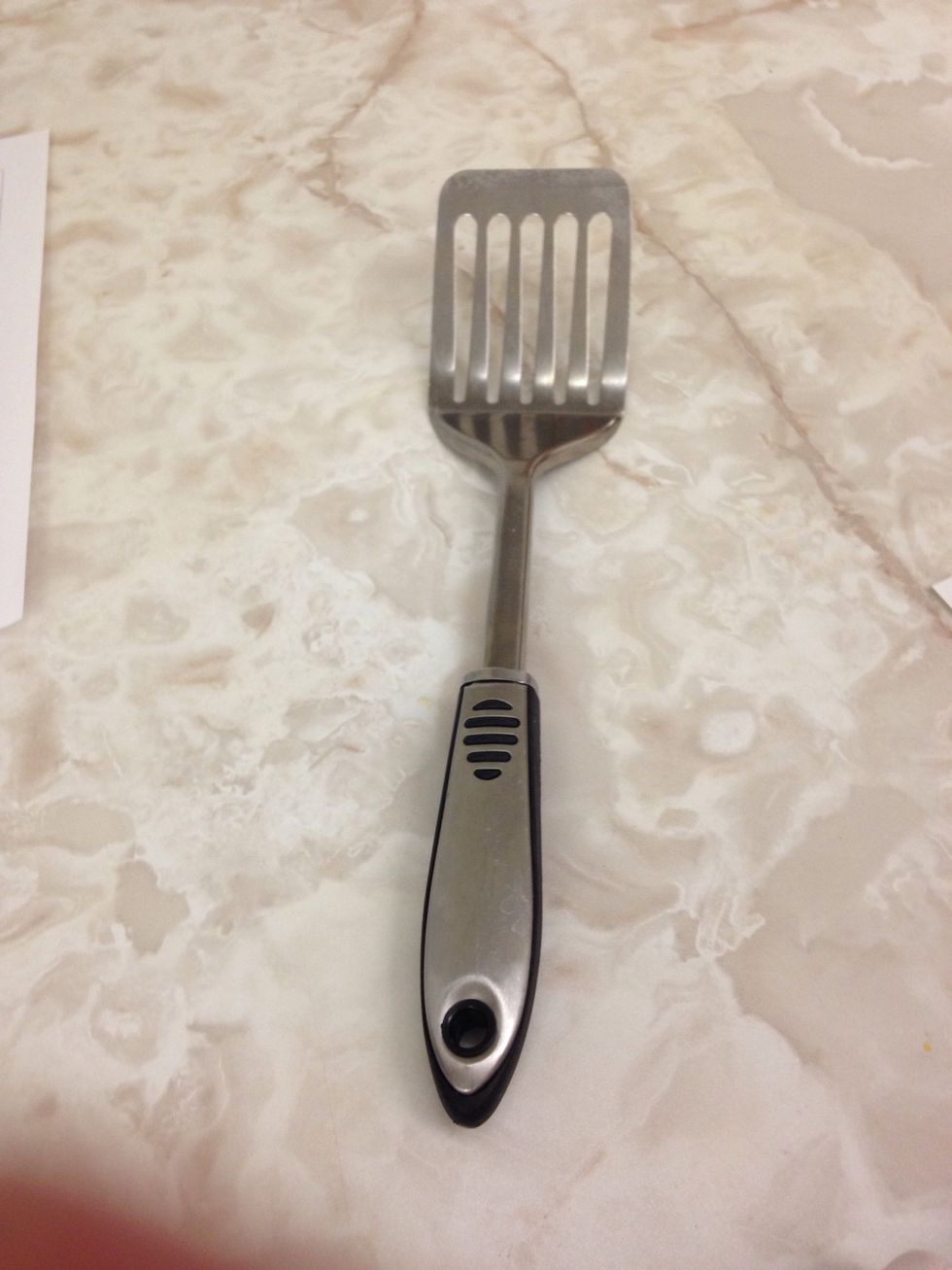 Une spatule en métal est utilisée pour retourner des choses comme des hamburgers. Je peux l'utiliser pour cuisiner des hot-dogs, des saucisses, des hamburgers.