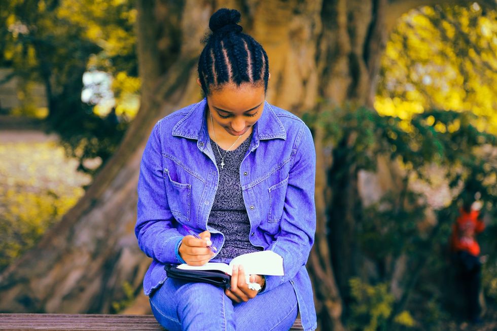  woman sitting outside writing