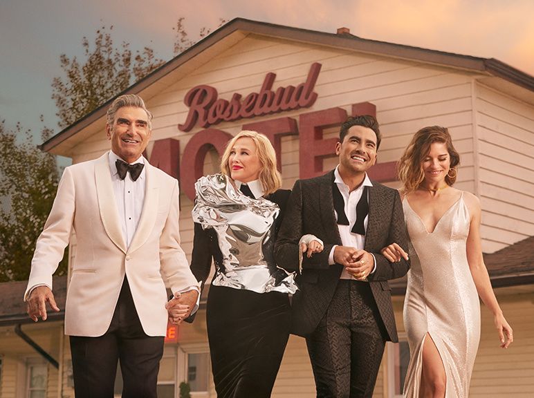 The Rose family of Schitt's Creek all dressed up and linking arms