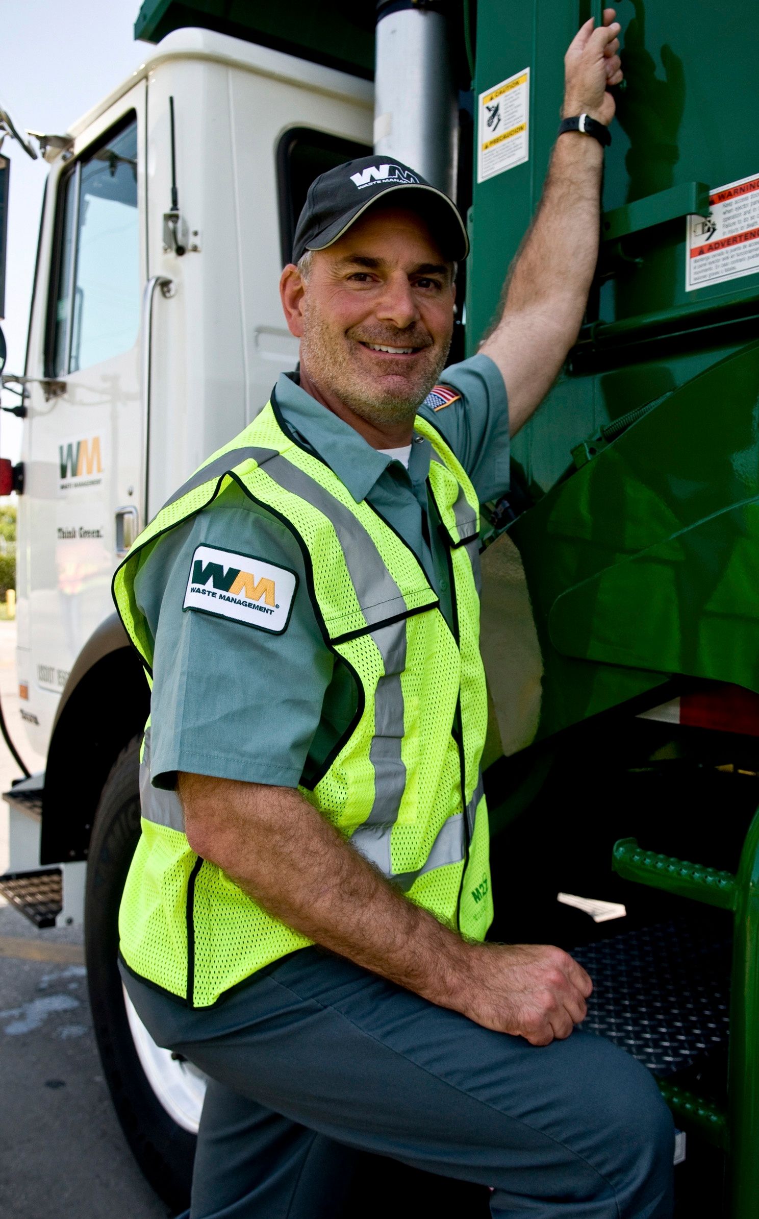 Waste Management COO Larry O'Donnell in uniform next to a truck