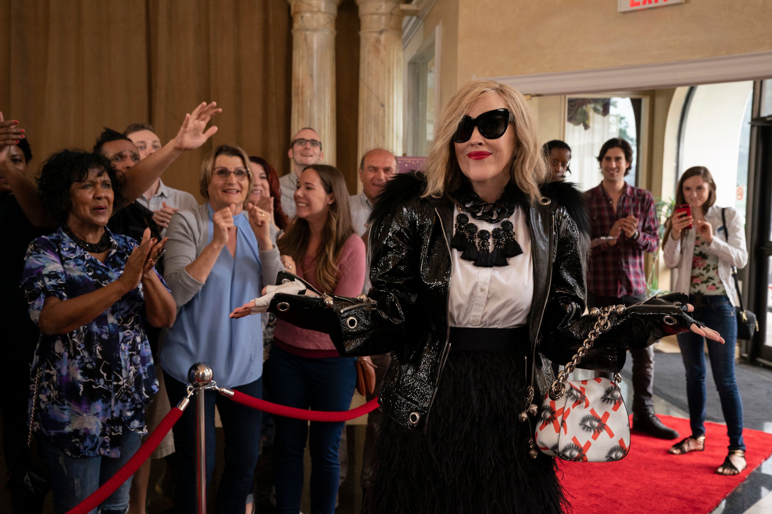 Moira poses on the red carpet while adoring fans admire her from behind a velvet rope