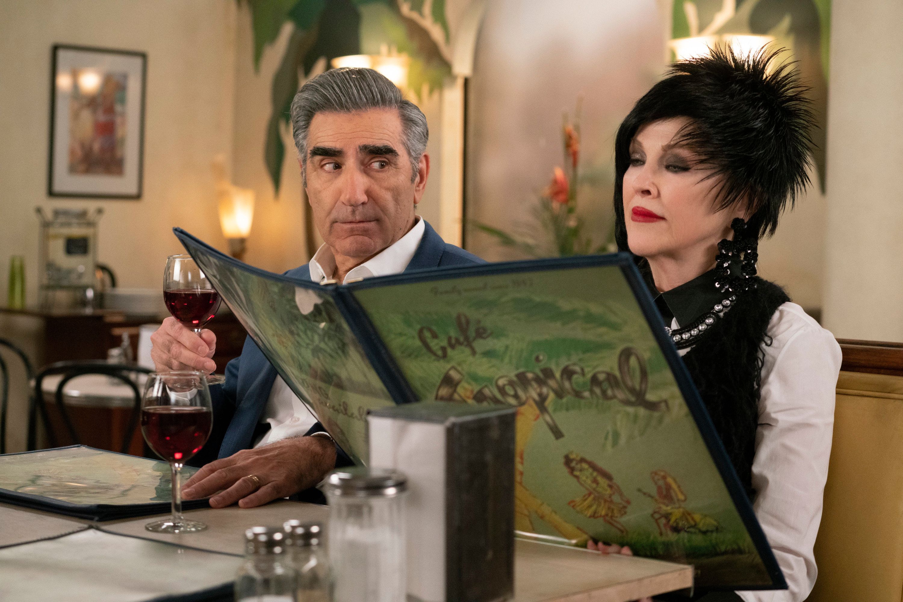 Johnny looks on as Moira peruses the menu at Cafe Tropical