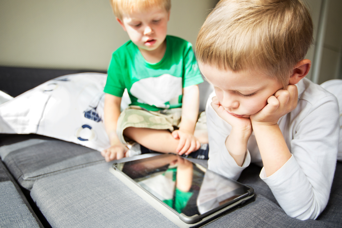 two kids using a tablet while watching muzzy