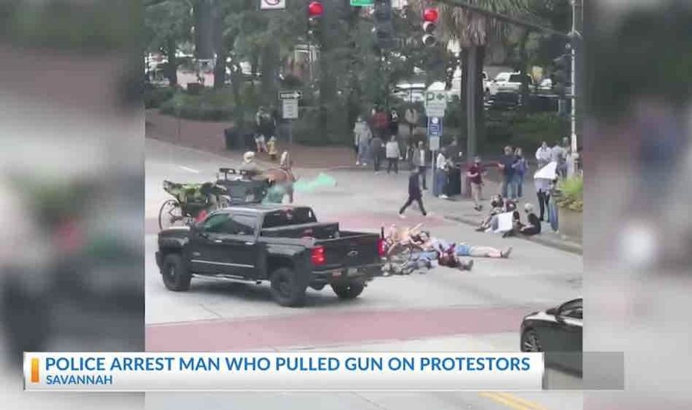 Motorist pulls gun on Black Lives Matter protesters attacking his truck. They were blocking road, and he tossed smoke grenade at them, cops say.
