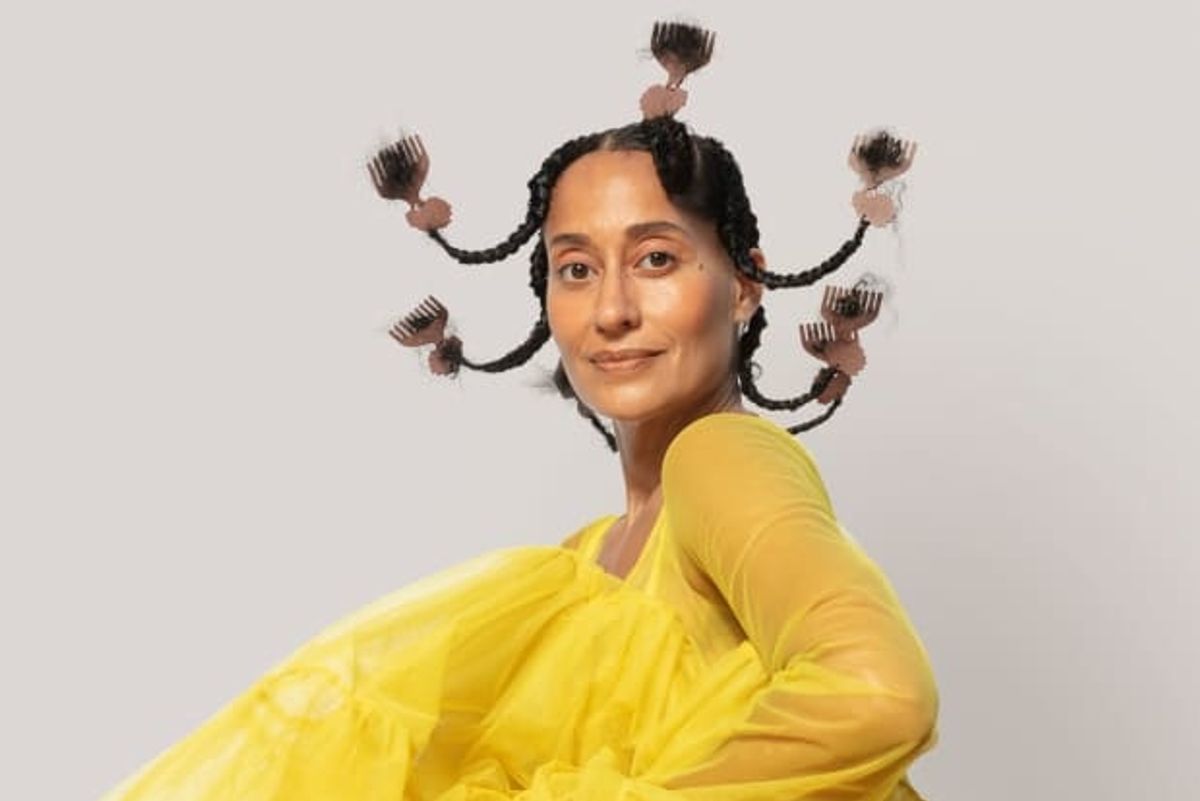 Tracee Ellis Ross on the cover of Elle magazine in a voluminous yellow dress and her hair in upturned plaits with small pick combs at the ends