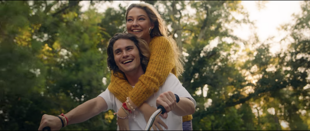 Chase Stokes and Madelyn Cline on a bike in Kygo's new music video for "Hot Stuff"