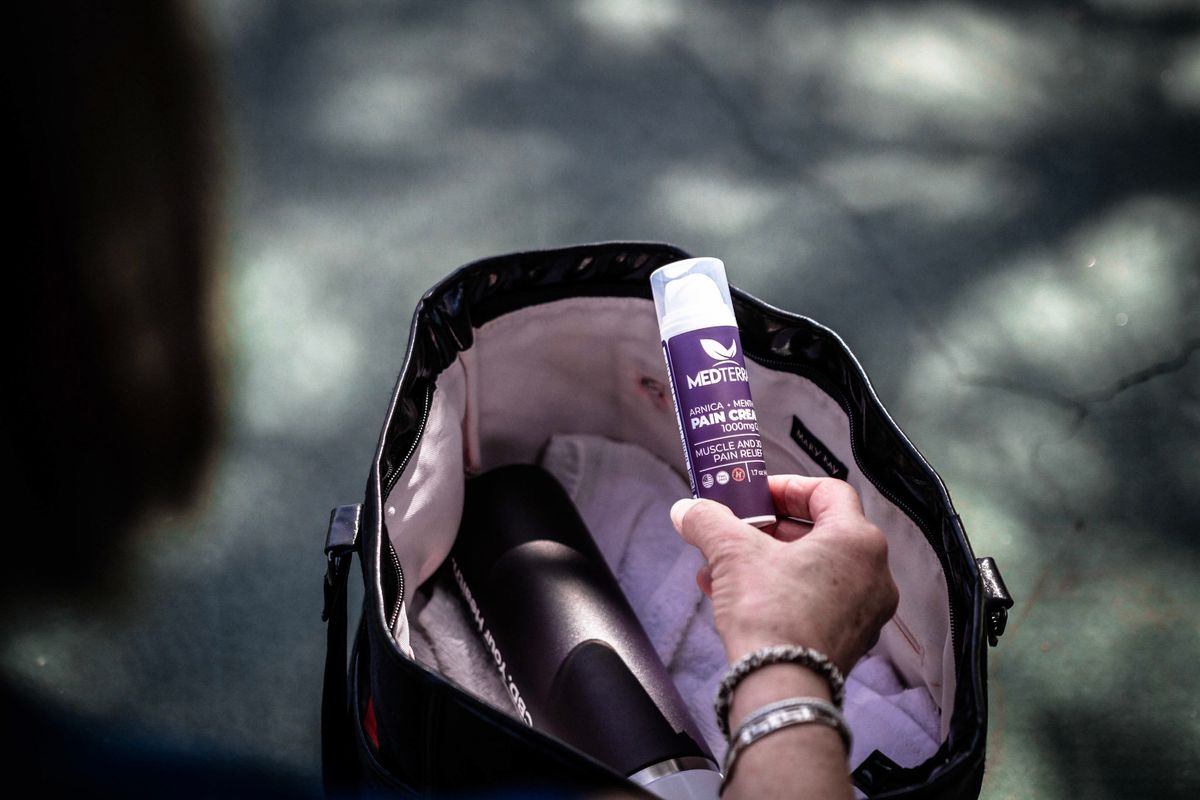 woman taking medterra pain cream out of her bag