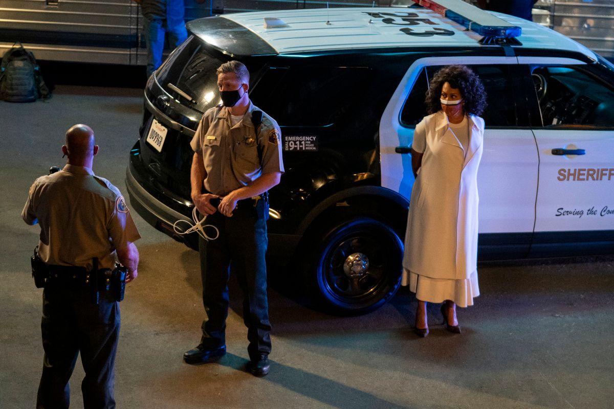 Lola Carmichael is detained in front of a cop car