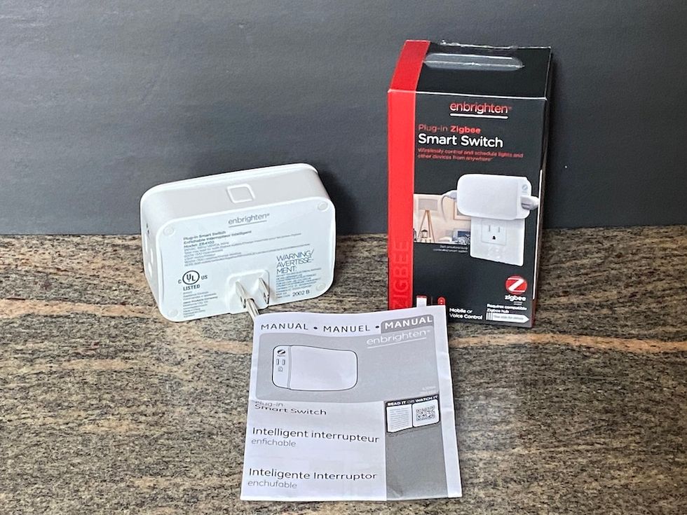 Photo of Enbrighten Smart Switch Zigbee box, plug and instructions on a countertop