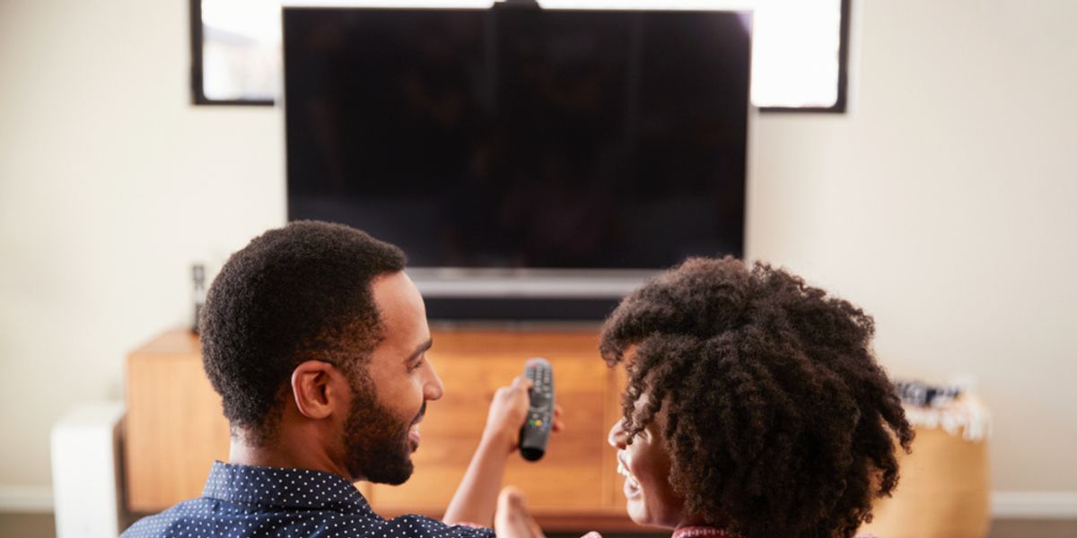 black-couple-remote-sitting-on-couch-tv