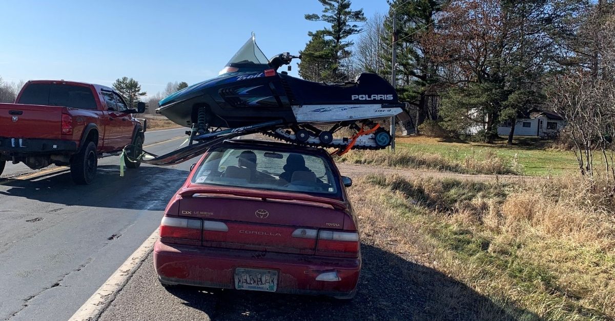 Driver Pulled Over For Having A Snowmobile Precariously Strapped To The Roof Of His Car