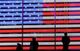 People stand next to a screen displaying a U.S. flag in Times Square during the 2020 U.S. presidential election in New York City, New York, U.S. November 4, 2020.