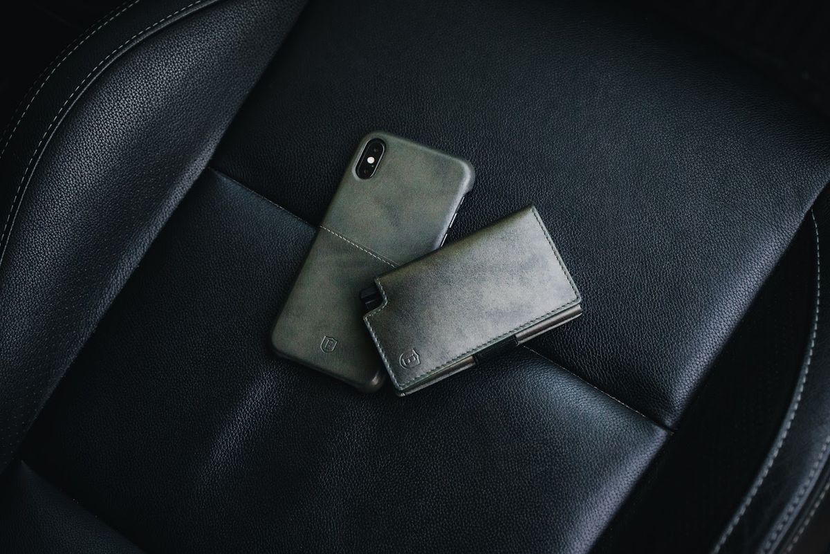 black leather car seat with Ekster wallet and iphone with Ekster phone case