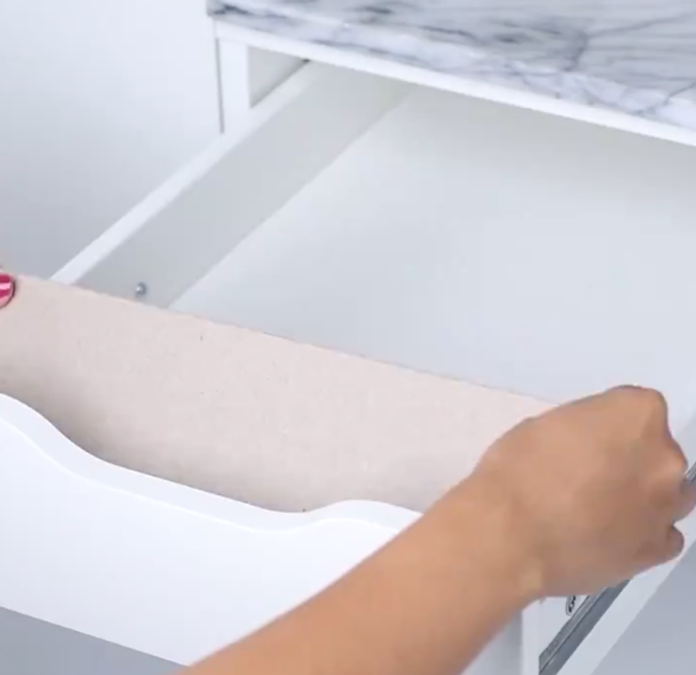 A woman places a small ramp into a drawer
