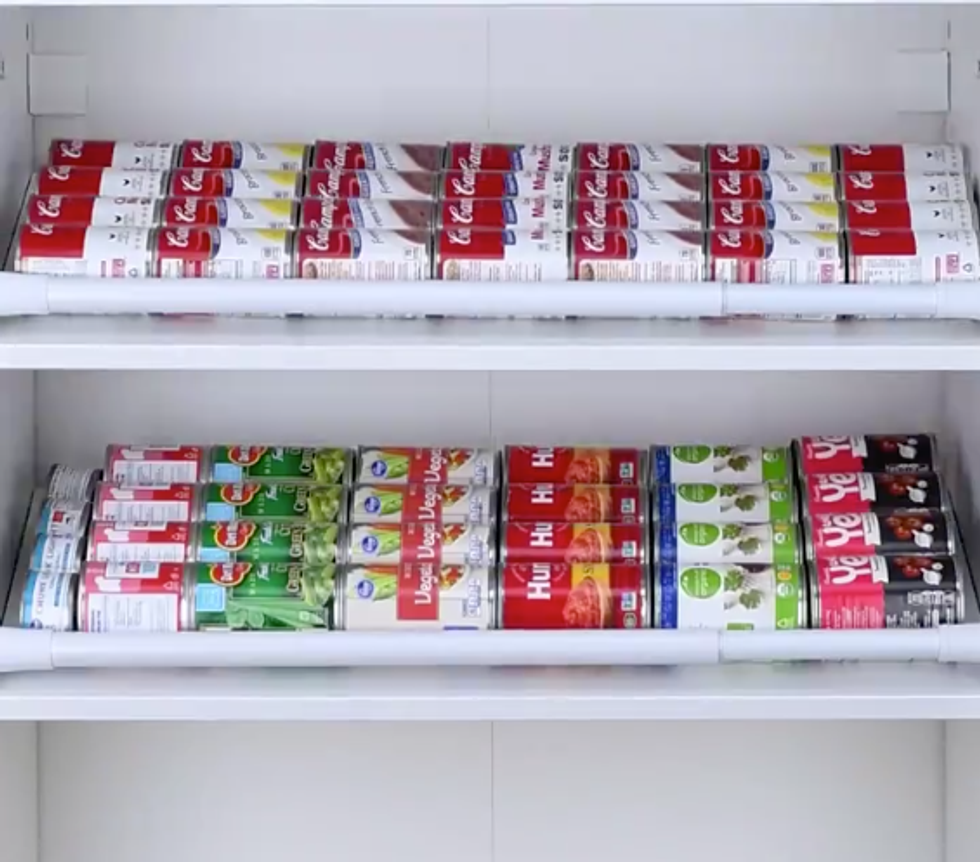 Soup cans sit neatly end to end in a pantry