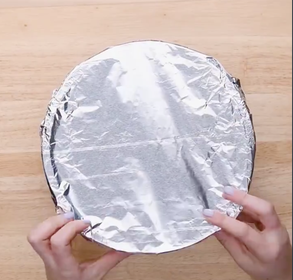 A top down view of a bowl covered in tinfoil
