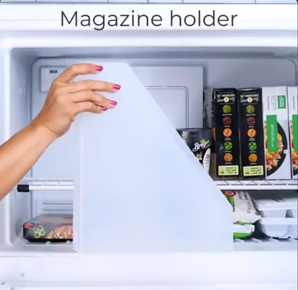 A hand holds a magazine holder