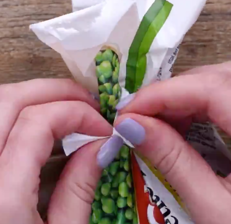 Hands tie a plastic tie around the frozen peas