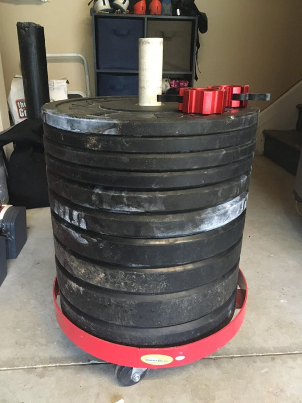 A pile of weights is placed over the top of a PVC pipe to make a neat pile