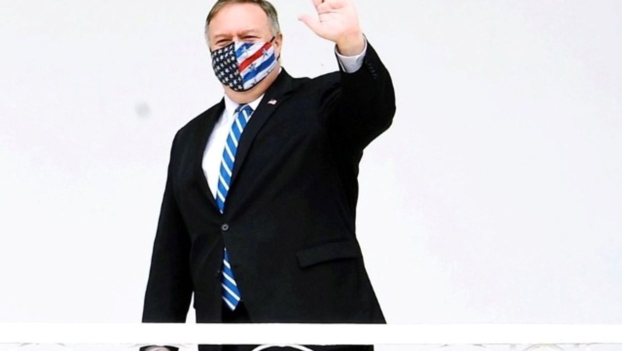 Mike Pompeo waves with mask on.