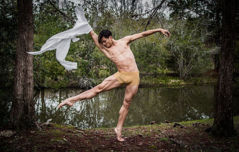 Chun Wai Chan, wearing tan booty shorts and near a wooded creek, piques on his left foot and stretches his right leg in degag\u00e9 \u00e0 la second. He lifts his right arm up and tosses a gauzy white shirt.