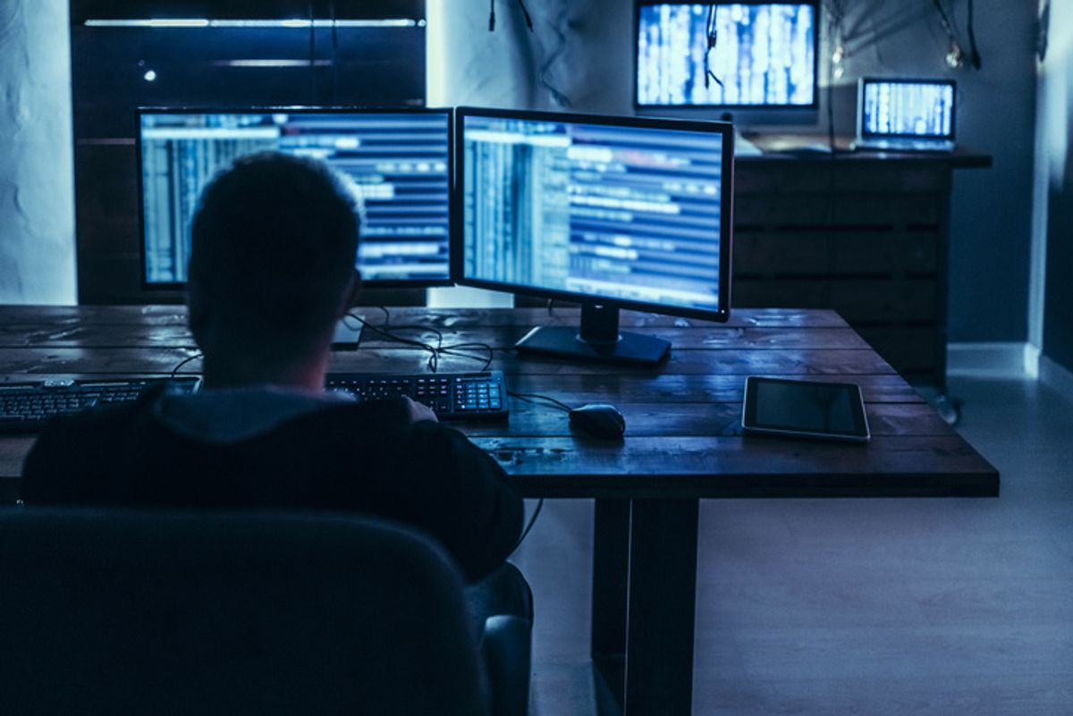 A bank of computer monitors running code