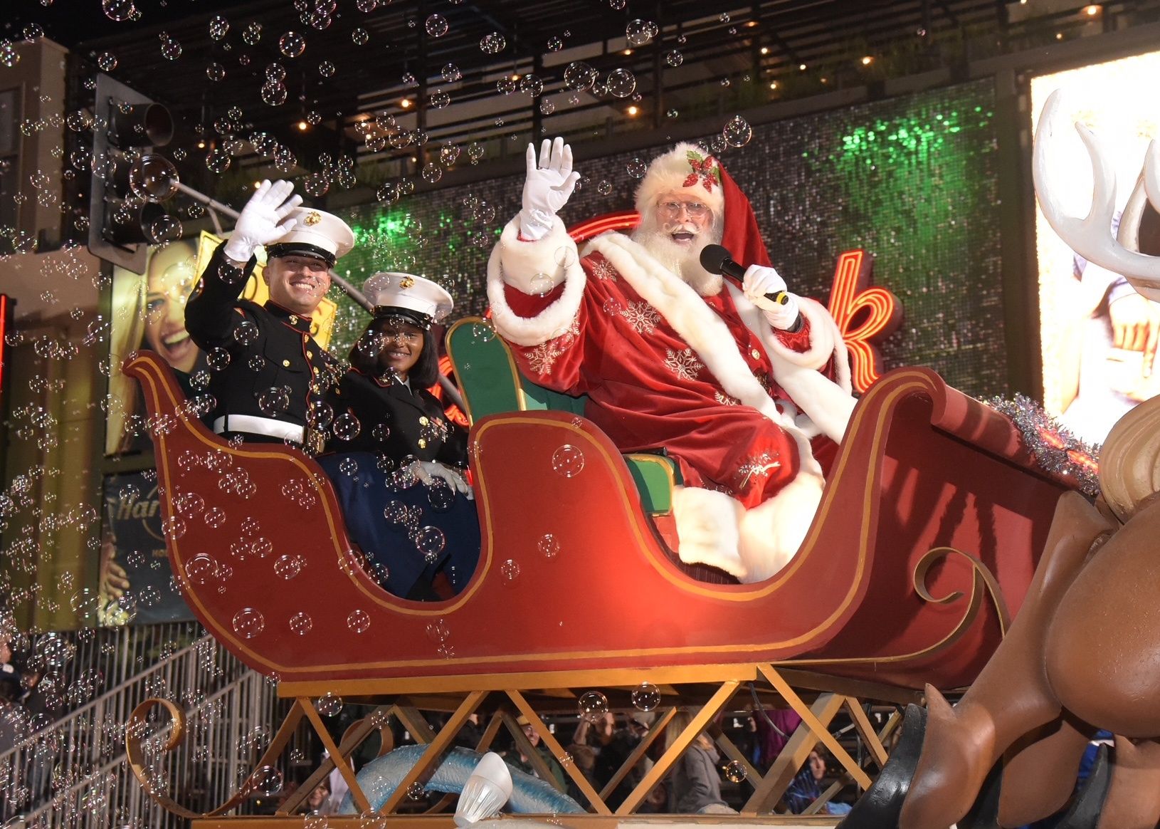 \u200bSanta Claus and service members wave from the sleigh