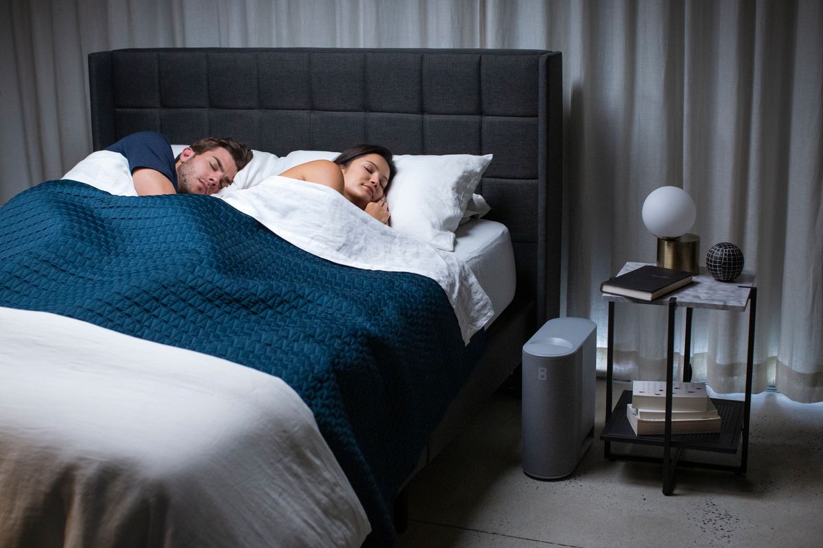 woman and man in bed sleeping next to eightsleep pod