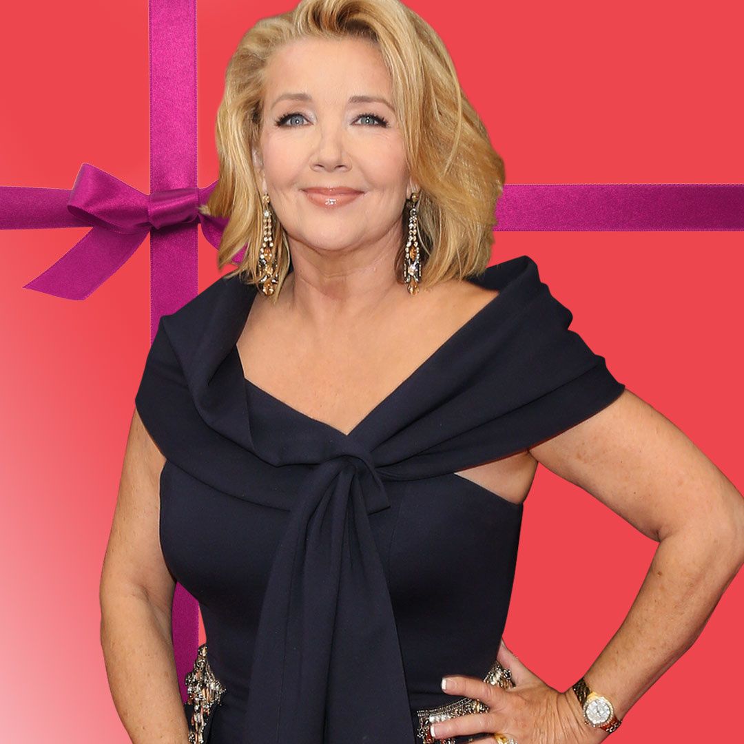 Melody Thomas Scott in a Roberto Cavalli gown against a coral colored background.