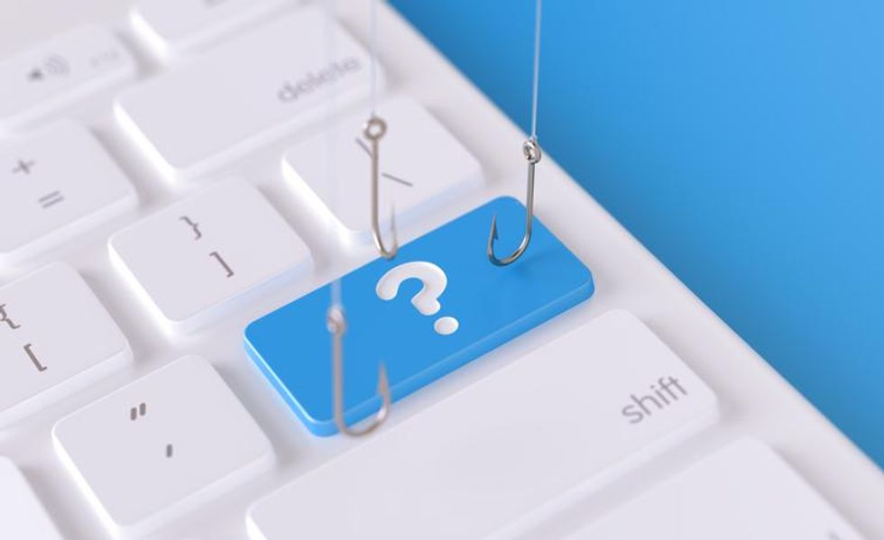 A computer keyboard with fishing hooks, illustrating a phishing attack